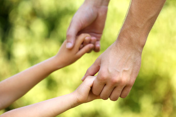 Father and daughter hands outdoors