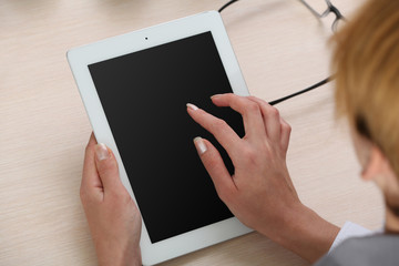 Woman using digital tablet on workplace close up
