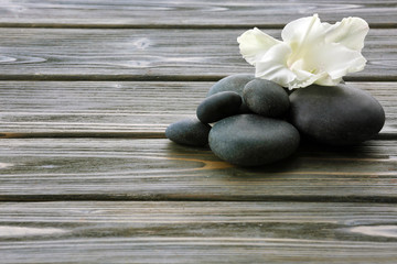 Fototapeta na wymiar Spa stones with flower on wooden background
