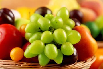 Heap of fresh fruits and vegetables in basket close up