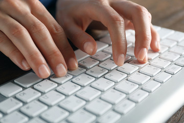 Female hands typing on keyboard close up