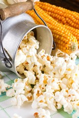 Popcorn spilled from can next to corncobs