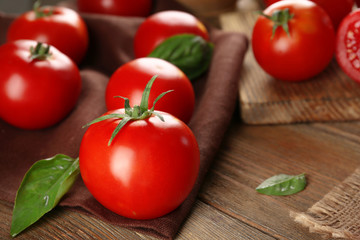 Red tomatoes on napkin on wooden background
