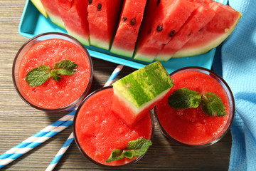 Glasses of watermelon juice on wooden table, top view