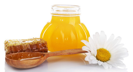 Pot of honey, wooden spoon and honeycomb isolated on white