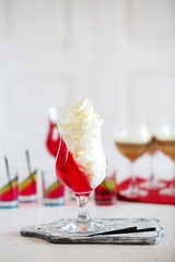 Tasty Jelly desserts with cream on light background