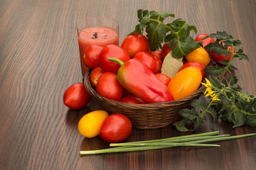 glass of juice and tomatoes in basket