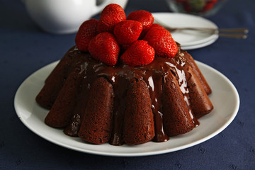 Delicious chocolate cake with strawberries in plate on table, closeup