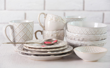 Clean dishes on table on brick wall background