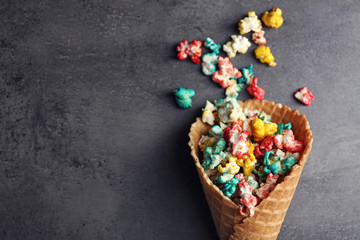 Coloured popcorn in the waffle cup on dark background