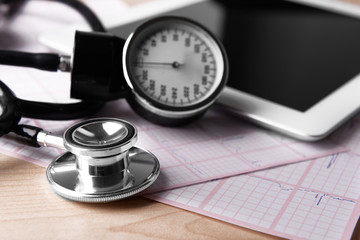 Blood pressure meter, digital tablet and stethoscope, on wooden background