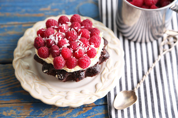 Sweet cake with raspberries on wooden table background