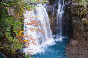 cascada y poza de agua azul turquesa en el bosque, en el Parque Nacional de Ordesa en otoño, España