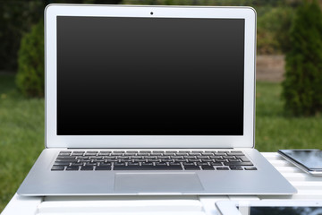 Fototapeta premium Laptop and papers on wooden table outdoor