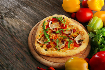 Heart shaped pizza and fresh vegetables on wooden background