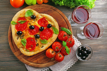 Heart shaped pizza served with wine on wooden table