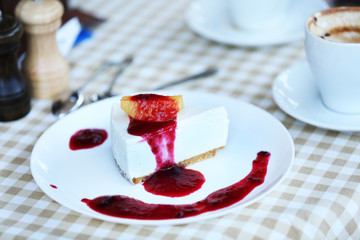 Delicious cheesecake with sauce on table in cafe