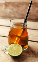 Iced tea with lemon on wooden background