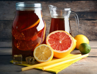 Iced tea with lemon and grapefruit on wooden background