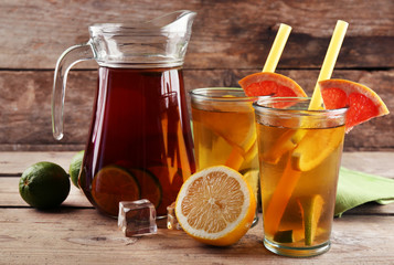 Iced tea with lemon and grapefruit on wooden background