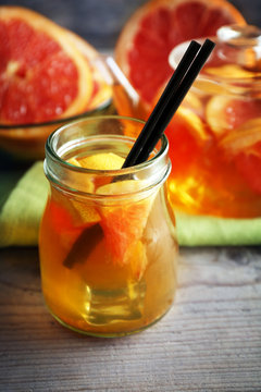Iced tea with lemon and grapefruit on wooden background