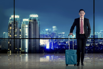 Fototapeta na wymiar Asian business man carry suitcase with city background