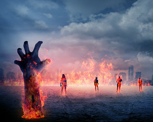 Zombie hand with fire rising from the ground