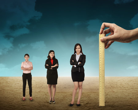 Hand holding wooden ruler, mesuring employee performance