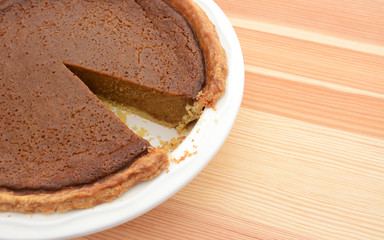 Close-up of cut pumpkin pie with slice taken