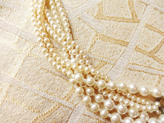 Fototapeta na wymiar strand of pearls on beautiful fabrics