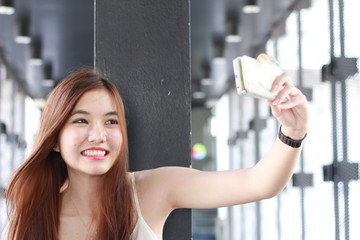 Portrait of thai adult beautiful girl using her smart phone Selfie.