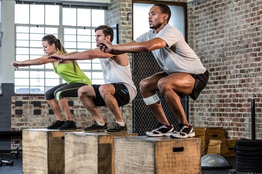 People doing squats in gym