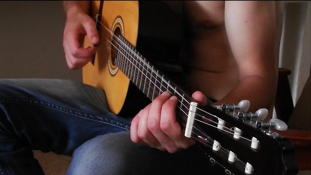 young boy learning to play guitar