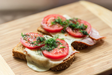 Morning breakfast sanwiches on a wooden cutting board with blurr