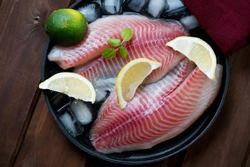 Above view of iced tilapia fillets in a frying pan, close-up
