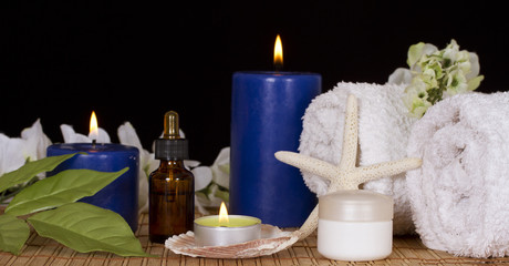 Bottle with spa essence,spa candles,flowers and cream