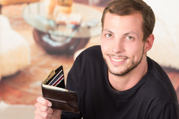Hispanic male wearing dark sweater looking into camera holding