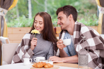 Attractive young boyfriend and girlfriend are resting in cafe