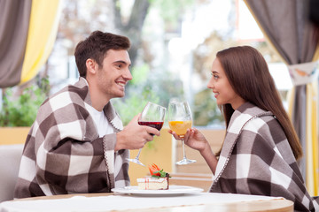 Cheerful boyfriend and girlfriend are dating in restaurant