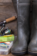 fishing tackles and rubber boots on timber board