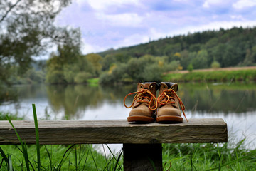 Schuhe auf einer Holzbank in der Natur