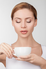 Beautiful young woman is enjoying hot coffee