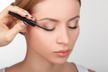 Fototapeta premium Skilled young beautician is doing make-up for girl