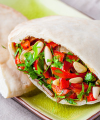 Pita bread with meat, parsley, tomato, bell pepper and pine seeds