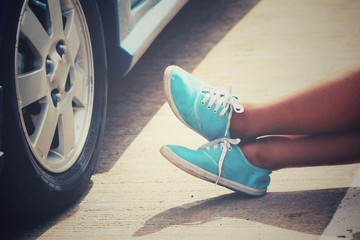 Woman with sneaker and car on the road