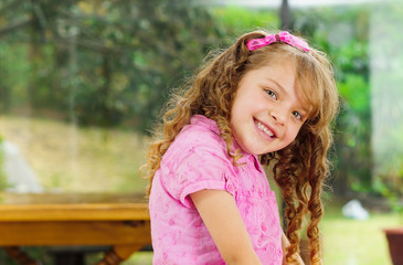 Beautiful young hispanic girl with pink clothing smiling cute at