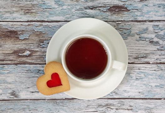 Cup of black tea and heart shaped cookies