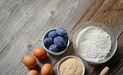 Baking plum cake on wooden table