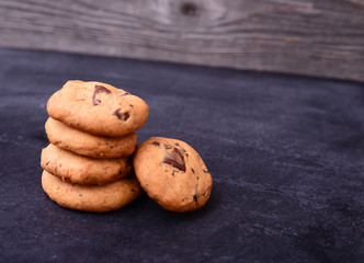 Chocolate cookies on black table. Stacked chocolate chip cookies