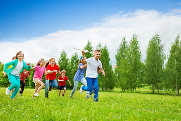 Obraz premium Boy with big airplane toy and children behind